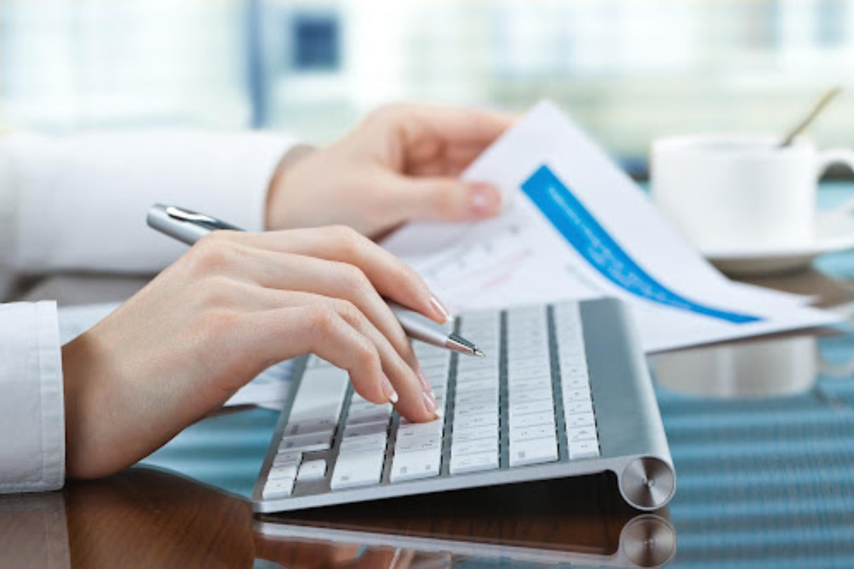 Woman’s hands on computer with tax paperwork